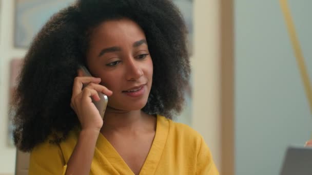 非洲裔美国妇女微笑着民族女商人女经理商业女孩雇主女售货员在办公室用手提电脑讲手机打电话咨询客户谈话 — 图库视频影像