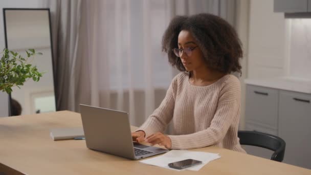 アフリカの少女 アメリカのビジネス女性 フリーランサー ホームキッチンでラップトップ作業 遠隔作業 疲れたビジネスマンのクローズ コンピュータノートブック メガネの排出ドライアイの緊張 — ストック動画