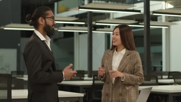 多様なビジネスパートナーの労働者 多民族の同僚 インドの男性 アラビアのビジネスマン アジアの女性 雇用主 韓国のビジネスウーマン オフィスで友好的な幸せな笑顔の会話 — ストック動画
