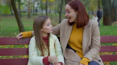 Park Autumn City 'deki mutlu Kafkas ailesi bankta anne-kadın konuşmaları, evlat edinilmiş kız çocuğu konuşmaları, kahkahalar, haberler, muhabbetler, kahkahalar.