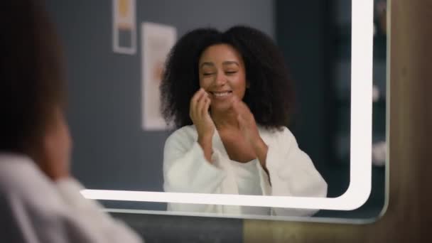 Mutlu Gülümseyen Afrikalı Amerikalı Kadın Aynaya Bakıyor Sabah Bornozuyla Şımartılıyor — Stok video