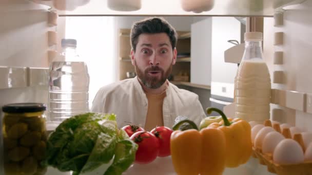 从冰箱里看Pov的观点白种人快乐有趣的成年人兴奋的看到冰箱里有很多有机食品的男人说哇 亲吻西红柿送超市 — 图库视频影像