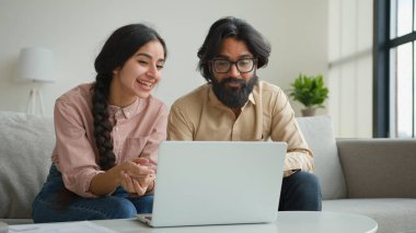 Gülümseyen Arap iş adamı çift Müslüman kadın görüntülü konuşma webcam laptop konferansı ev ofisindeki çok ırklı erkek kız arkadaş canlısı sanal sohbet karantinada gülüşmeler