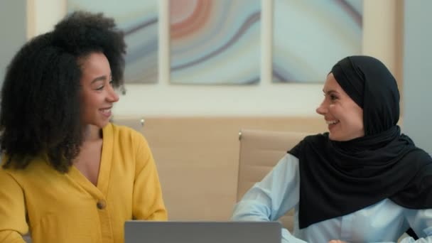 多种族商业伙伴办公室同事非洲裔美国人伊斯兰穆斯林妇女头戴头巾各种各样的快乐兴奋的女商人赢得了项目笔记本电脑的成功5个手势团队精神 — 图库视频影像