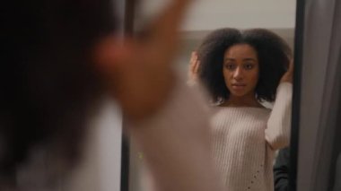 Ayna yansıması güzel mutlu Afro-Amerikan kadın moda kızı sağlıklı bayan pohpohlayan saç stili kıvırcık saç stili güzellik hayran olunarak mağazada buluşmaya hazırlanan neşeli kadın gülümsemesi