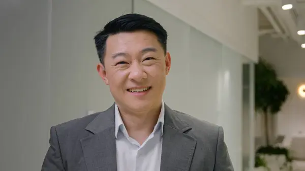 Portrait Asian happy man ethnic chinese japanese businessman male korean middle-aged smiling executive employer business owner leader in corporate office hallway looking at camera dental toothy smile