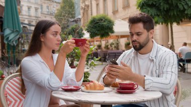 Hayal kırıklığına uğramış genç bir kadın, Kafe Kafe 'nin dışındaki kahve şehrini gücendirmiş, boşanmış, cep telefonuyla meşgul bir adam, çift ilişkileri sorununu görmezden geliyor.