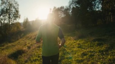 Geriye bakış sporu tanınamaz bin yıllık beyaz erkek adam iz sürme koşucusu koşucu koşucu koşu rotası antrenmanı triatlon güneş ışığı güneş ışığı dağ doğumu doğa ormanı