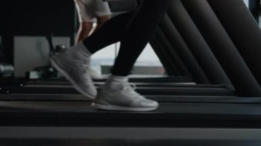 Spor ayakkabılı kadın ayaklarını kapat koşu bandında yürü koşu bandında yürü koşu makinesinde yürü aktif spor yap koşucular antrenman antrenmanlarına hazır spor koşucuları spor salonunda koşu yarışı yap