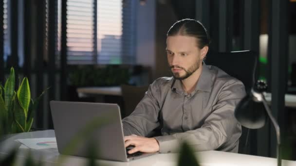 沉思的白种人商人在晚上的办公室里上网打字 深思熟虑地把目光投向一边 把思考问题的商人男人看成是有计算机解决方案的执行雇主 创造出想法 — 图库视频影像