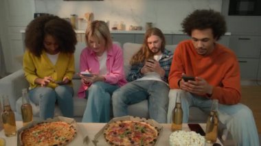 Çok ırklı arkadaşlar, çok ırklı çeşitlilikler, cihazlar, cep telefonları, akıllı telefonlar, aşırı kullanım, sıkıcı bağımlılığı görmezden gelme, sosyal medya, ev kanepesinde pizza bağımlılığı.