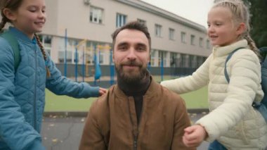 İki kız baba yanağından öpüyor mutlu aile babası mutlu kız liseli kızlar beraberliği destekleyen ilkokul tatlısı baba samimi baba dışarıda sevgi dolu çocukları kucaklıyor