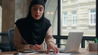 Müslüman yoğunlaşmış Müslüman Müslüman kadın Arap kız iş analisti kadın çalışan yönetici çalışma evrakları renkli istatistik tasarımcısı iş kadını şeması ofiste dizüstü bilgisayar kullanarak tesettüre girdi