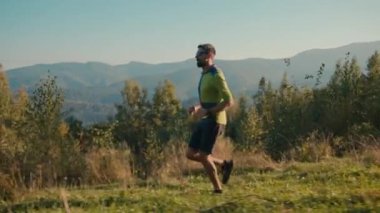 Kafkasyalı erkek sporcu aktif kardiyo egzersizi, yürüyüş parkuru gezgini güneşli yeşil doğa aktivitesi sağlık hizmetlerinde seyahat eden sporcu.