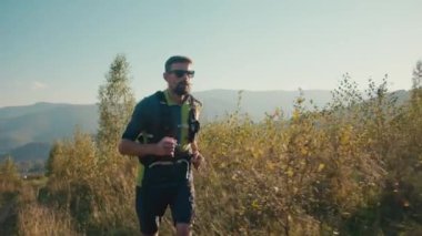 Odaklanmış Kafkasyalı erkek koşucu koşucu koşucu spor giysi yoğun koşucu erkek maraton koşucu dayanma gücü vücut bakımı sabah erken saatte rutin sağlıklı alışkanlık çayırlık vadi tepesi