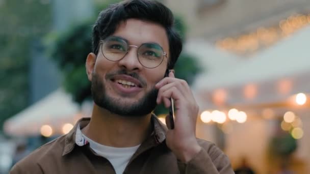 ハッピー笑顔のインドのアラビアの民族男性観光ビジネスマン 友好的な会話を持っている男 歩くこと 携帯電話の通話 観光都市の通り — ストック動画