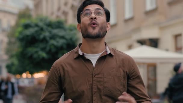ポートレートは驚きました インドのアラビアの民族の男性学生男性男性男性 ビジネスマン 開いた口の勝利 市街地の外で広い笑顔の肯定的な表情を叫ぶことを祝って叫びます — ストック動画