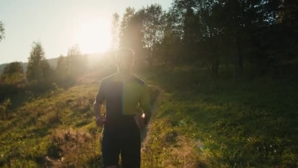 健康なコーカサスミレニアル男性ランナースポーツウェアは 日当たりの良い山の丘を走っています スポーツマントレーニングランニング トレーニング 自然ハイカー ジョギング ハイキング カーディオ スポーツ — ストック動画