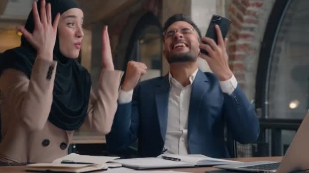 快乐兴奋惊喜交集的多民族女性获奖者商业伙伴穆斯林女商人在Hijab阿拉伯商人中获得了手机好消息庆祝成功赢得了五个手势 — 图库视频影像
