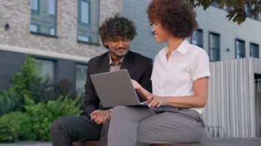 İki farklı iş ortağı çok ırklı işçiler Hintli erkek Afrikalı kadın bilgisayar analistleri şehir dışında şirket projelerini tartışarak online verileri tartışıyor.