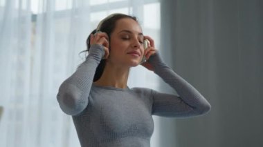 Kafkas fitness kadını formda, mutlu, gülümseyen, kulaklık takan, kulaklık takan, cep telefonu uygulamalı, müzik kulaklıklı bir kadın.