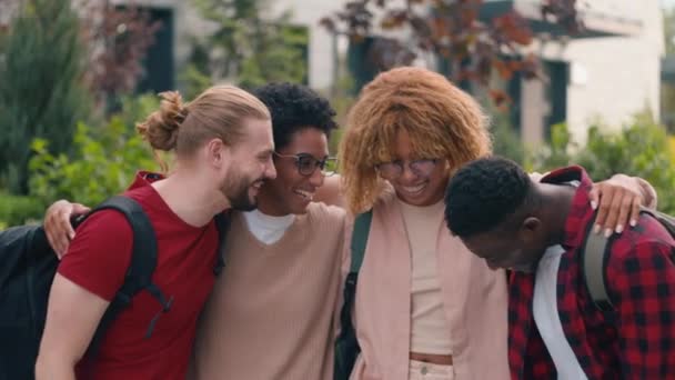 多样化的多种族微笑快乐的谈话交流有趣的笑声学生们朋友们高中大学学院在城市里拥抱在一起看着相机 — 图库视频影像