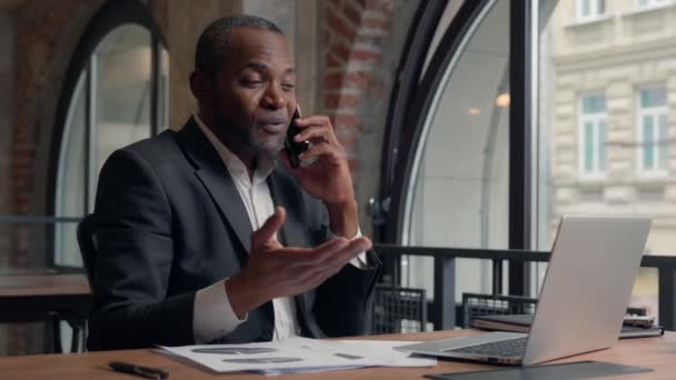 Multitasking Upptagen Afroamerikansk Entreprenör Med Bärbar Dator Pappersarbete Kontrollera Data — Stockvideo