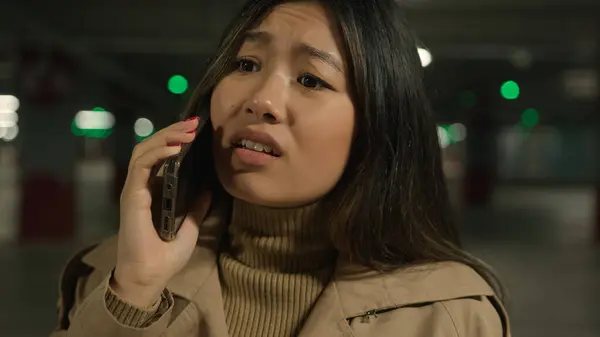 恼怒的亚裔中国女人强调韩国语女孩会讲手机的对话 讨论如何解决女性客户在停车时的争执 图库照片