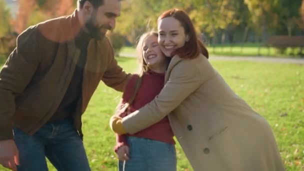 ハッピーコーカサス家族は 晴れた市の秋の公園で休日の週末を抱擁する笑い 小さな子供の少女娘は笑顔保険を抱きしめ健康な人々 ゲーム — ストック動画