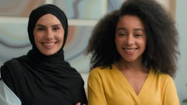 Kurumsal portre iki çok ırklı kadın neşeli gülümseyen çok ırklı iş kadınları Afrikalı Amerikalı kadın ve Arap müslüman kız tesettürde iş ortakları
