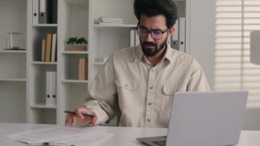 Arap Hintli iş adamı erkek işadamı işveren ofis yöneticisi analist dizüstü bilgisayar uzaktan kumanda iş projesinde çalışan ciddi bir işçi.