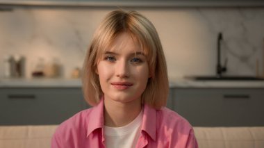 Kapalı portre sükuneti, gülümseyen Kafkasyalı genç kız öğrenci bayan bayan ev sahibi ev sahibi ev sahibi ev sahibi ev sahibi ev temizlikçisi kanepe sigortası kredisini rahatlatmak için kameraya bakıyor.