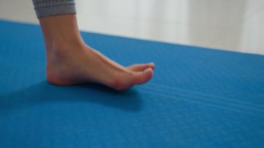 Kadın bacakları kapatın jimnastik minderi yoga sınıfındaki çıplak ayaklı kadın spor salonunda sabah antrenmanına hazırlanıyor bayan spor eğitmeni sağlıklı yaşam tarzı spor yapıyor.