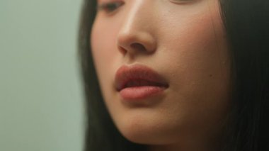 Asyalı genç bayan nilüfer çiçeği kokan dişi doğal koku hassasiyetini içine çekiyor. Kapalı Çinli kız saflığı kokusu taze bahar çiçeği tomurcukları aroma çiçeği güzellik sağlığı