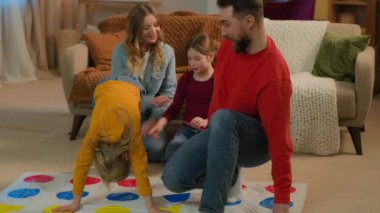 Kafkasyalı mutlu bir aile hafta sonu evde oyun oynuyorlar. Çocuklar aileleriyle oynuyorlar. Kaygısız anne babaları var.