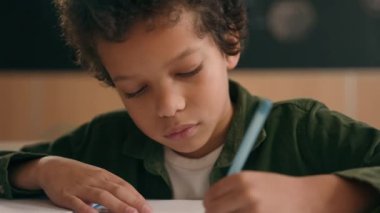 Afrikalı Amerikalı okul çocuğu, çocuk, etnik çocuk, okul çocuğu, öğrenci, kitap yazma görevi, ilköğretim öğrenimi, matematik dersi.