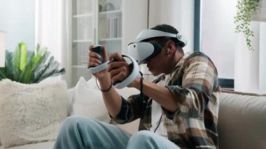 Afrikalı Amerikalı oyuncu, sanal alemde meta-dünyanın tadını çıkarıyor. VR oyunu oynayan etnik erkek oyuncu erkek oyuncu, sanal gerçeklik takıyor. Kask takıyor, kumanda kumandası takıyor.
