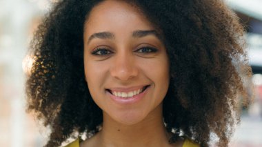 Yüzü kapatın neşeli Afro-Amerikalı kadın gülümseyen alışveriş düşkünü kadın kozmetik surat ağızları kameraya bakıyor iyi bir tatil makyajı zevkli bir kız portresi