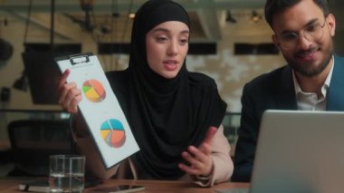 Arap Hintli erkek Müslüman kadın tesettür meslektaşları pazarlama grafikleri, sunum videosu, konferans görüntüsü, gülümseme, kadın iş kadını takım çalışması ofisi.