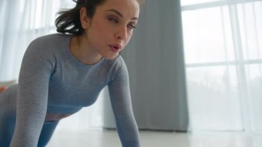 Spor kıyafetleri içinde güçlü, formda, beyaz bir kadın sporcu spor spikeri sabah antrenmanında yerde egzersiz yapıyor kadın güç kaybı kilo kaybediyor sağlıklı yaşam tarzı kadın fitness yoga