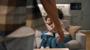 Acımasız Afrikalı Amerikalı baba baba, yumruğunu sıkmakla tehdit ediyor. Küçük kız, oğlan, kız kardeş kucaklaması. Kardeş, aile içi şiddeti evde istismar eden çocukları koruyor.