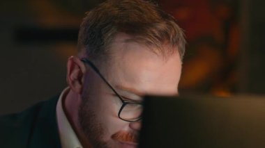 İşkolik işkolik iş adamı Kafkasyalı ofis işadamı işveren girişimci programcı erkek bilgisayarla gece geç saatlere kadar çalışıyor.