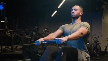 Afrikalı Amerikan fitness antrenörü güçlü atletik erkek sporcu sporcu formda forvet kaldırma simülatörünü spor spor egzersizinde itin kürek çekme makinesini aşağı çekme halat makaraları oturarak