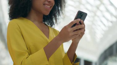 Afro-Amerikalı kadın kullanıcı cep telefonu akıllı telefon teknolojisi çevrimiçi internet sohbeti yapan kız gülümseyen alışveriş merkezi siparişi veren internet bağlantısı dijital cihaz