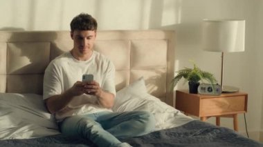 Kafkasyalı erkek yatak odası cep telefonu, akıllı telefon, internet, mesajlaşma, sohbet, internet, internet, internet, internet, internet, sosyal medya, tasasız eğlence.