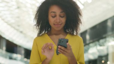 Neşeli Afrikalı Amerikalı kadın mutlu kız bak cep telefonu ekranı akıllı telefon sürpriz haber teknolojisi kadın alışveriş merkezi inanılmaz ifadesi ağzın tadını çıkar