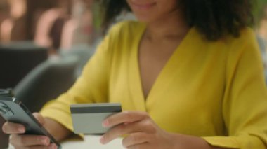 Cep telefonu akıllı telefon bankası kredisi kullanan Afrikalı Amerikalı bir kadın internette gülümseyen bir kameraya bakıyor elektronik teknoloji alışverişi yapıyor.
