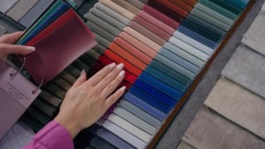Kadın elleri kız kumaş örnekleri seçer. Renkli palet kumaş aksesuarlar. İç tasarım tanınmayan kadın moda tasarımcısı.