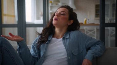 Beyaz tenli, kanepe kanepesinde acı çeken bir kadın el sallayan ev kadını, ferahlatıcı, yüksek hava sıcaklığı kırıcı yaz mevsimi sıcaklık kontrol sistemi hormonal dengesizliği azaltır.