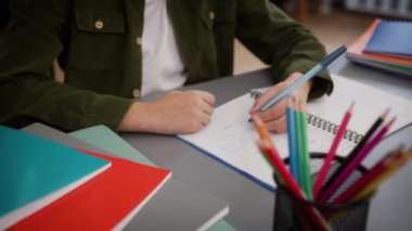Kesik bir bakış açısı tanınmayan küçük bir çocuk çocuk çocuk okul öğrencisi evde eğitim görüyor uzaklarda masa eğitimi öğrenimi okuyor okul ödevi matematik bilgisi yazıyor.